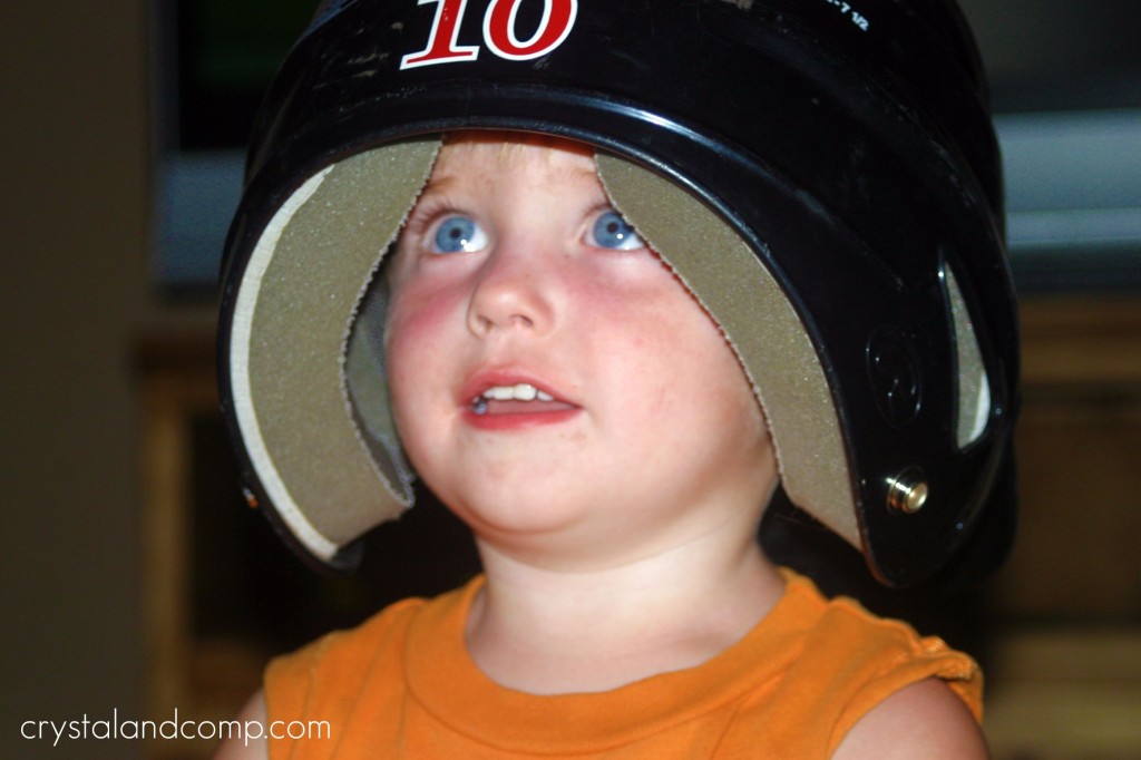toddler with baseball helmet