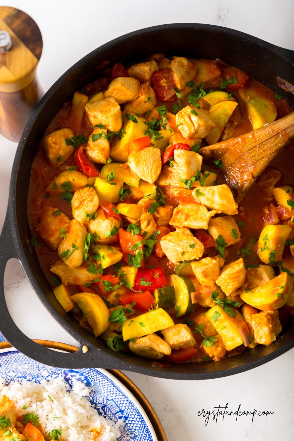 chicken and squash recipe in skillet wooden spoon