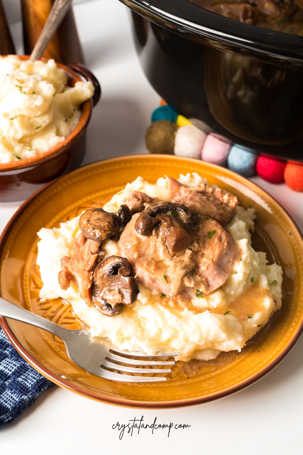 slow cooker smothered pork chops over mashed potatoes
