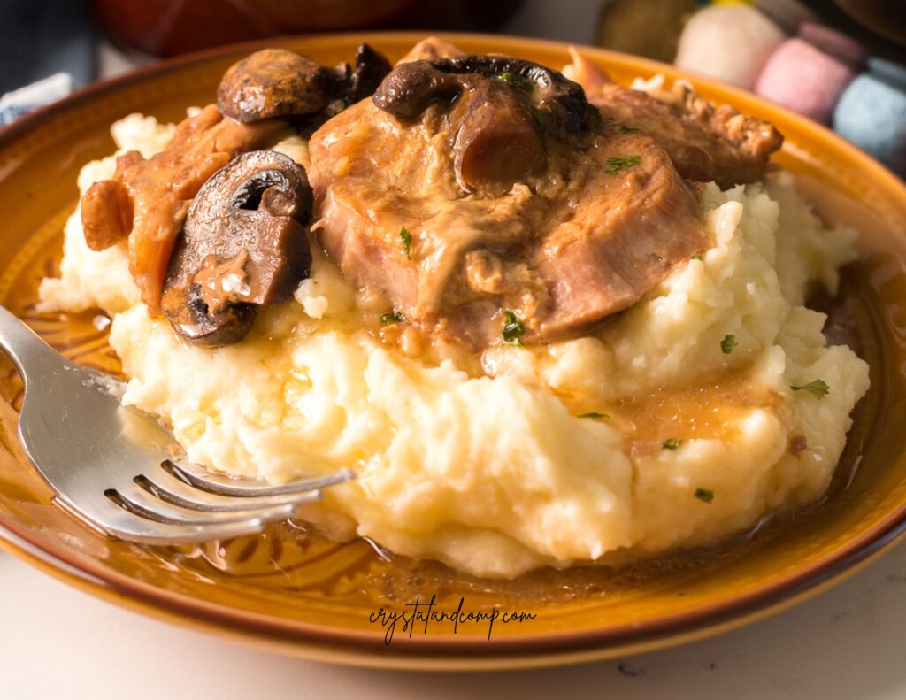 slow cooker smothered pork chops over potatoes
