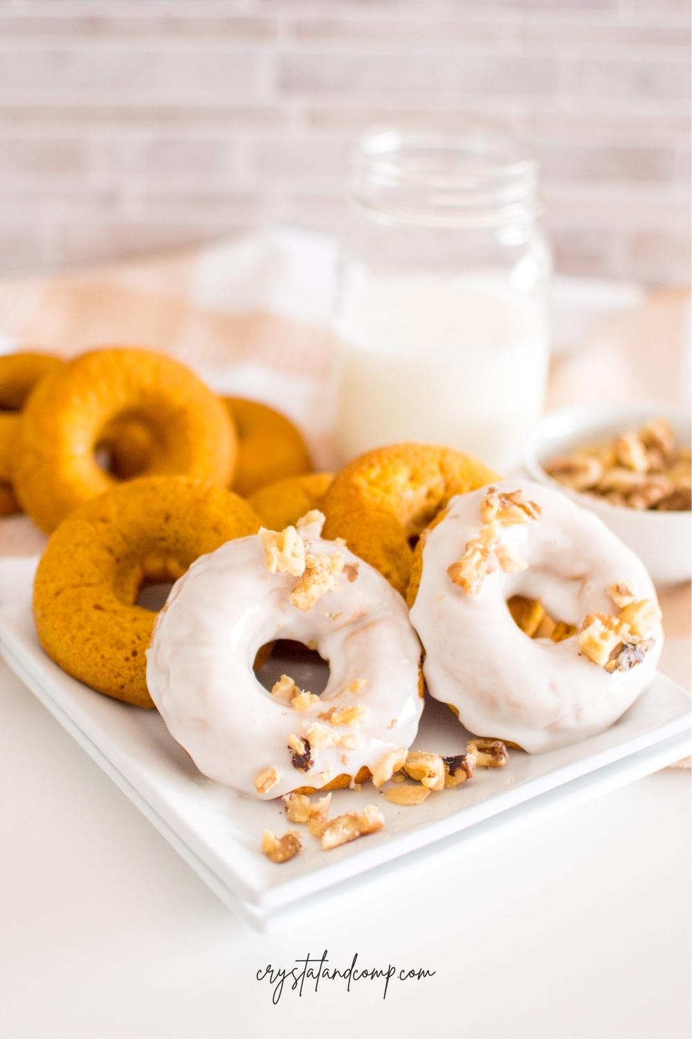baked pumpkin donuts with icing and walnuts