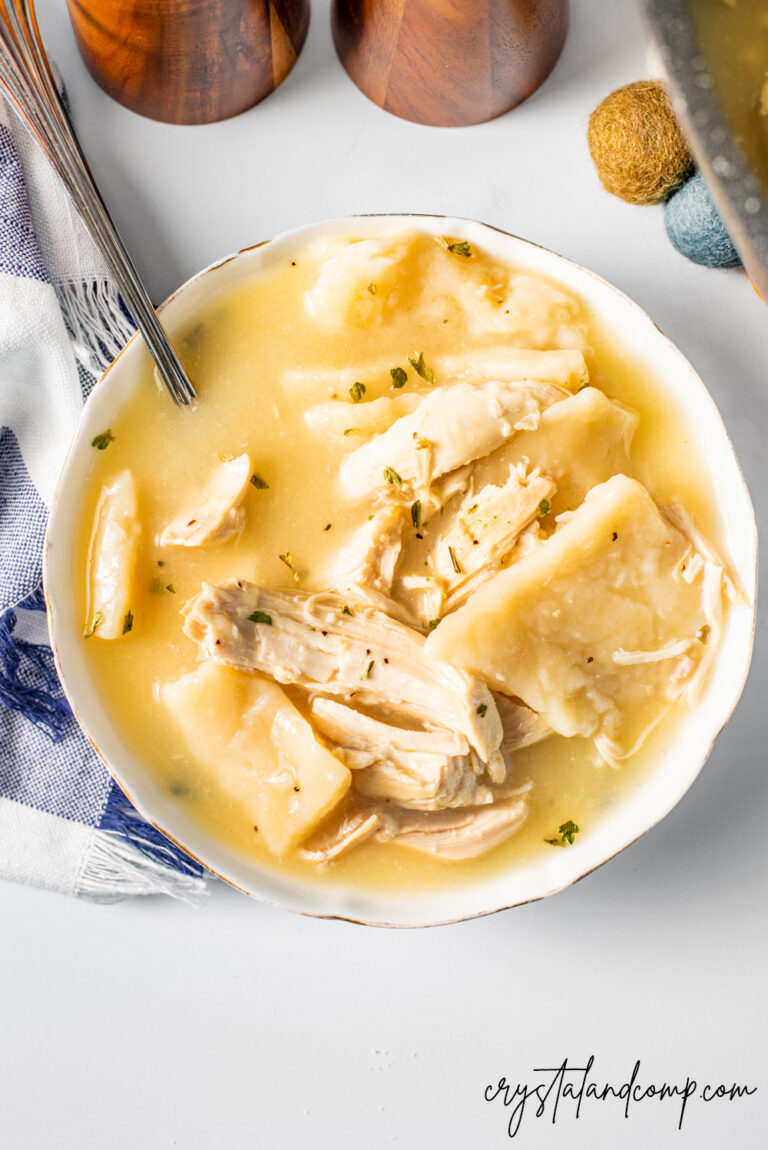 Golden chicken and dumplings in a white bowl